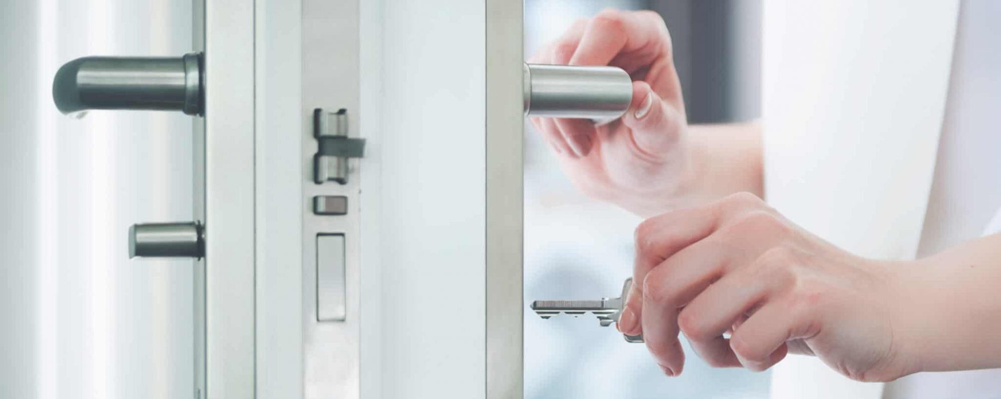 Locking or unlocking modern door with key in hand